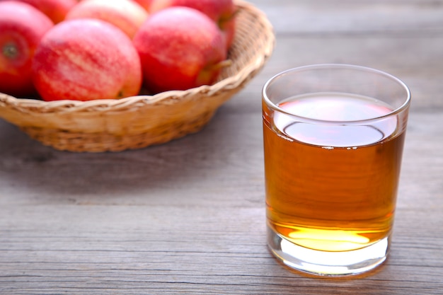 Mele rosse con succo su uno sfondo grigio