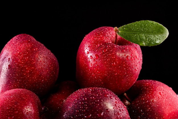 Red apples with leaves on dark background