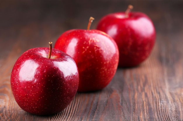 Red apples on wooden table closeup