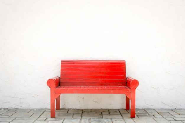 Red armchair a white wall and grey floor