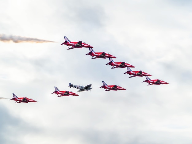Red Arrows 50-jarig jubileum op de luchthaven van Biggin Hill met een Supermarine Spitfire
