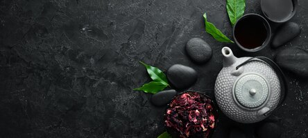 Photo red asian traditional tea hibiscus on a black stone background top view free space for your text