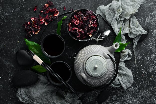 写真 赤いアジアの伝統的なお茶ハイビスカス黒い石の背景にあなたのテキストのためのトップビューの空きスペース