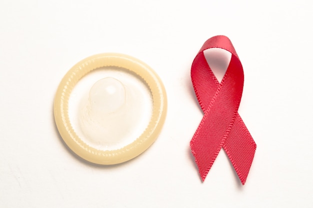 red awareness ribbon and condom
