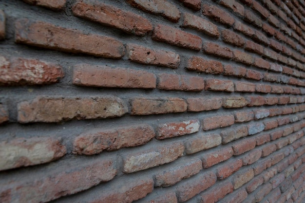 Fondo rosso di vecchia struttura del muro di mattoni dell'annata. vista ravvicinata del vecchio muro di mattoni in pietra con muratura medievale, fotografia prospettica foto di alta qualità