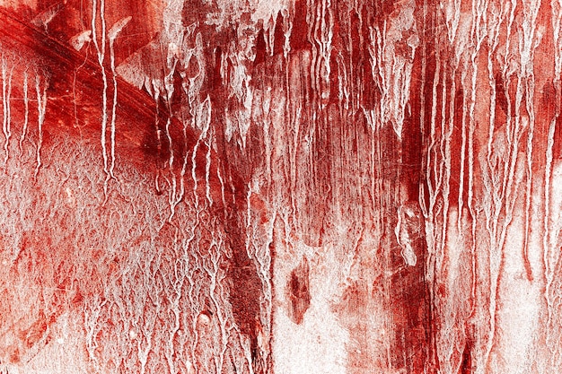 背景の壁の赤い背景の恐ろしい血まみれの汚れた壁は、血の染みや傷でいっぱいです