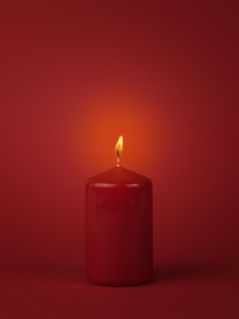 Красный фон с горящей красной свечой Концепция романтических отношений