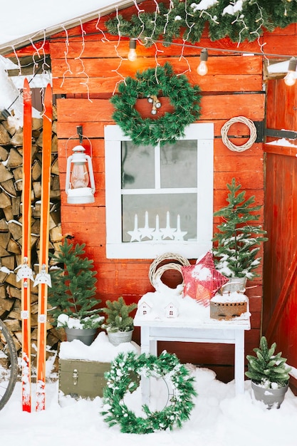 Portico rosso del cortile della casa rurale decorato per natale, natura morta invernale, vacanze di capodanno