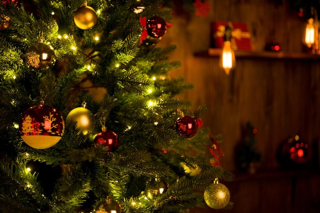 Red ball on a Christmas tree with a garland on the background of a wooden wall image