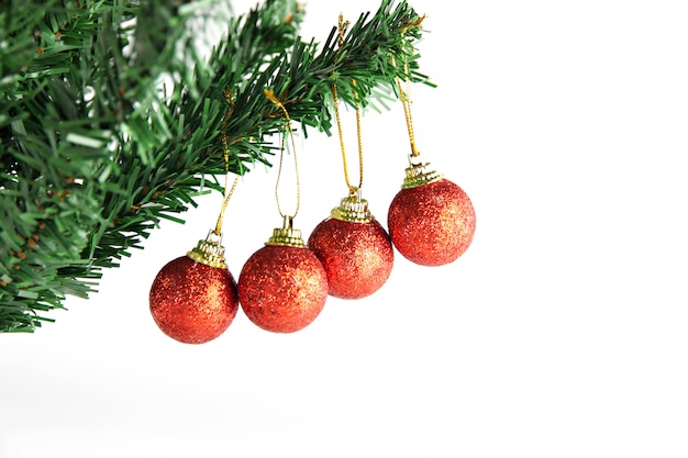 Red ball hanging on branch of Christmas tree.