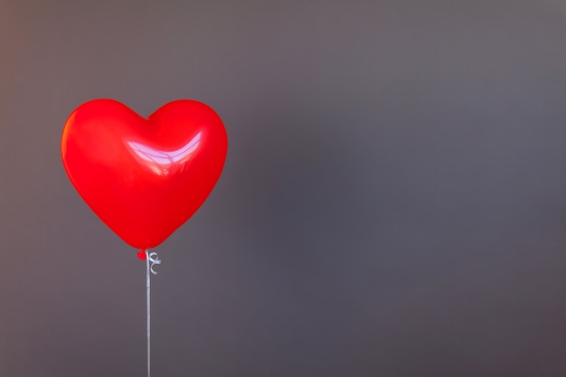 Red balloon heart shape on gray backround