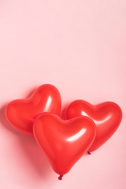 Photo red balloons on pink background with copy space