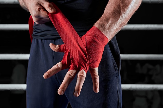 Foto bende rosse sulle mani di un kickboxer sullo sfondo