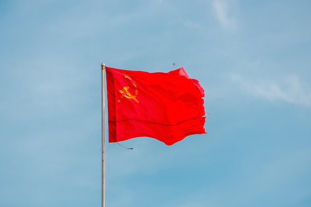 The Red Banner of Victory in World War II is developing in the wind against a clear sky