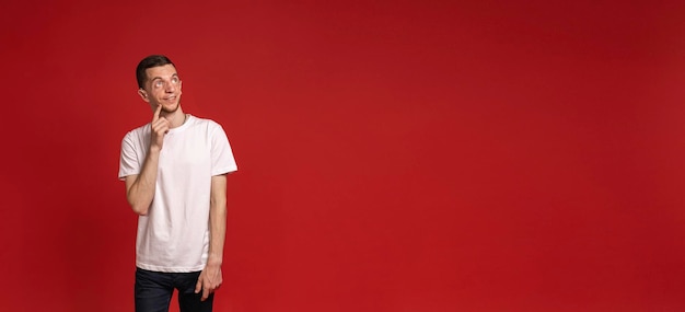 Red banner with a young man in a white Tshirt looking away advertising banner copyspace