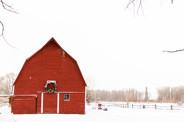 Красный сарай в снегу на ферме в Колорадо.