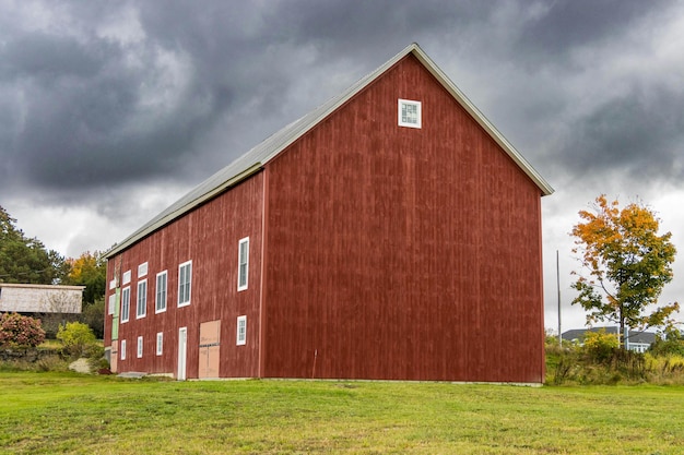 a red barn with a silver roof and a white square on the side