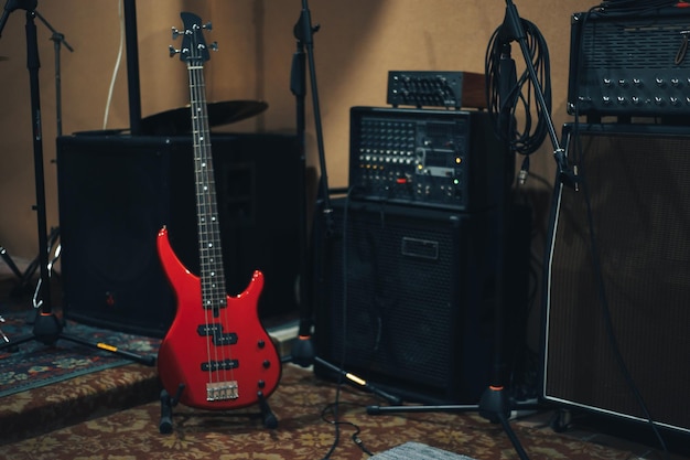 Red bass guitar on a home musical studio background