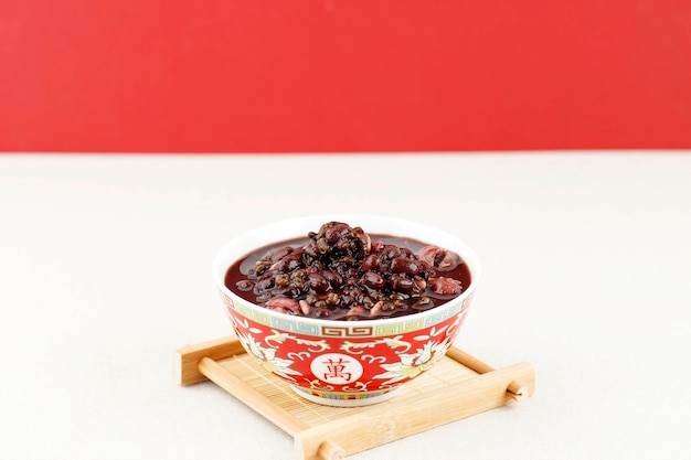 Red bean soup and purple rice porridge with milk pot on top of wood table