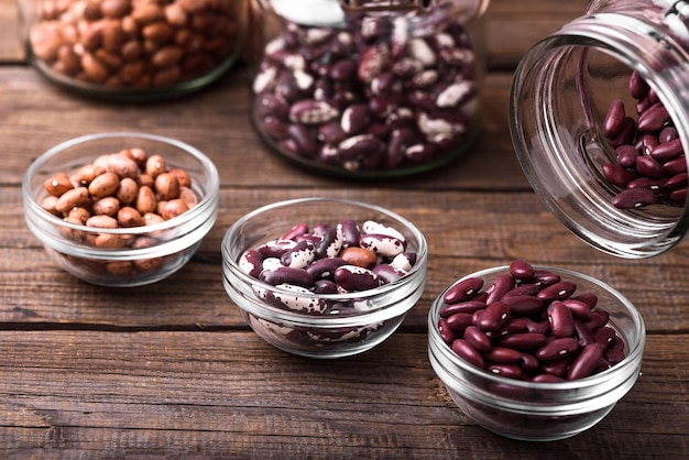 Photo red beans in a transparent glass over wooden background