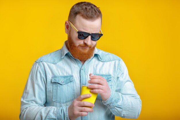 Red beard man holding cup with coffee