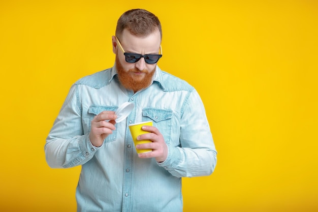 Red beard man holding cup with coffee