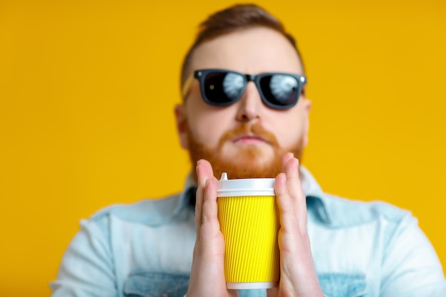 Uomo con barba rossa che tiene tazza di caffè