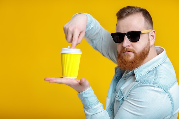 Red beard man holding cup with coffee