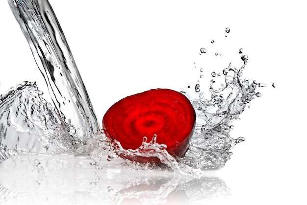 Красная свекла с брызгами воды, изолированные на белом фоне