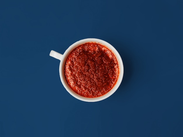 Photo red beetroot smoothie in a white mug on a blue background