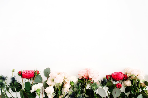 Red and beige rose flowers, eringium flower, eucalyptus branches and leaves. Flat lay, top view