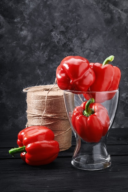 Красный болгарский перец в вазе на темном фоне. Свежие овощи и концепция питания