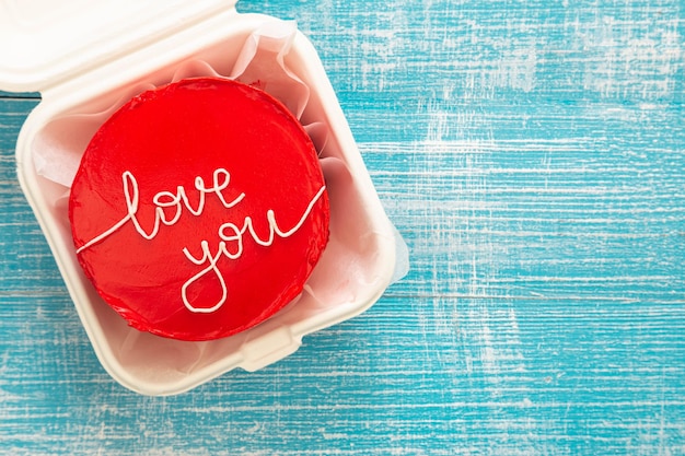 Red bento cake with I love you inscription on a wooden background top view