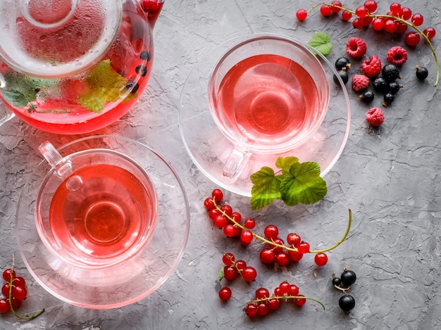 Red berries tea in cup and teapot