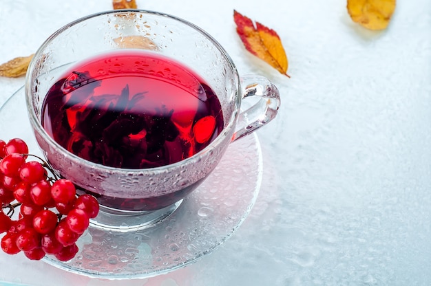 Viburnum di bacche rosse e tazza di tè