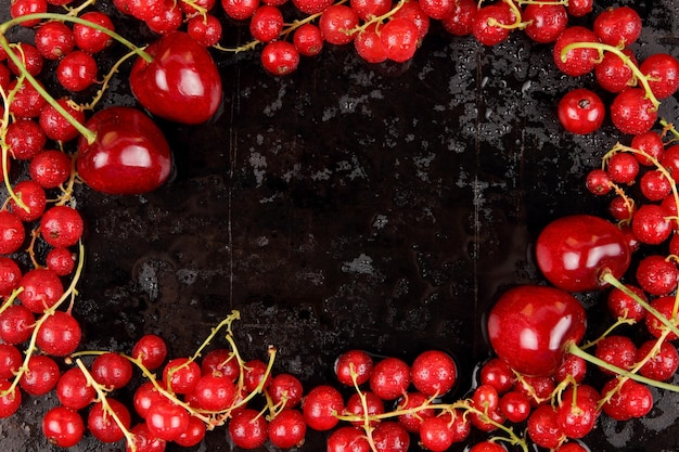 Red berries with drops of water on a black background View from above Healthy food concept