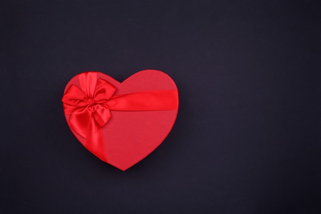 Red big heart-shaped gift for Valentine's Day on a black.