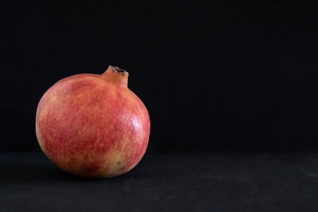 Red big pomegranate on dark background