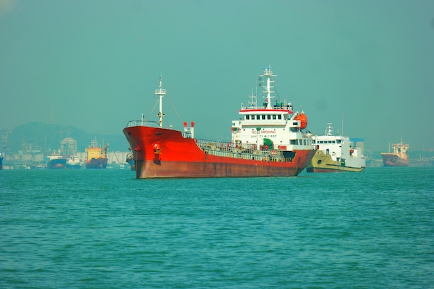 Red big ship on the blue sea under the clear sky