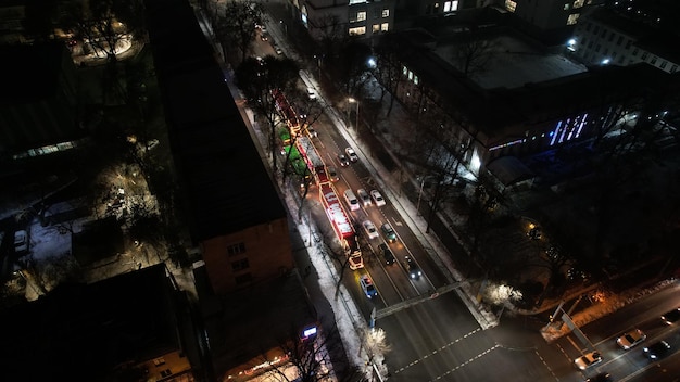 Red big trucks with coca cola drive through the streets of the city average traffic of cars lights a