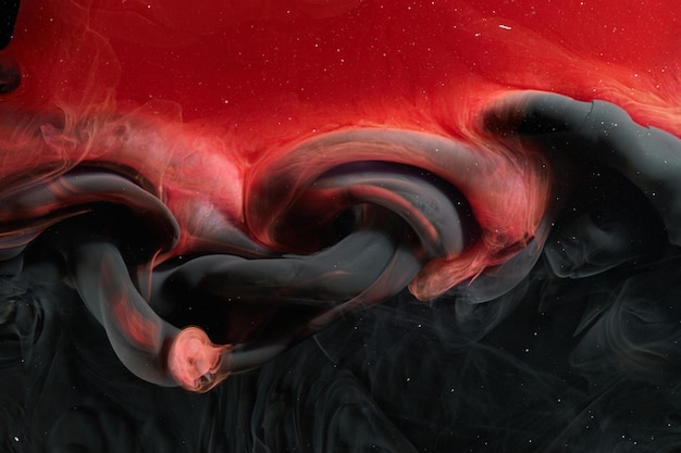 Red black abstract ocean background Splashes and waves of paint under water clouds of smoke in motion