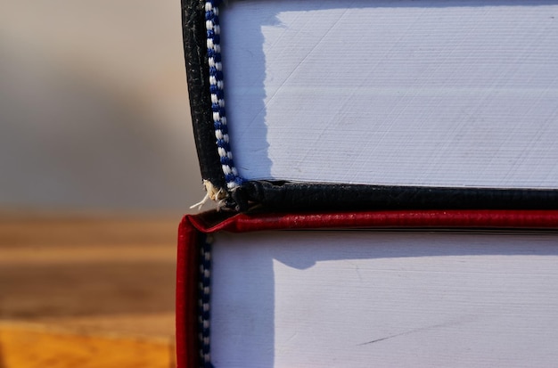 A red and black book is on top of a stack of books.