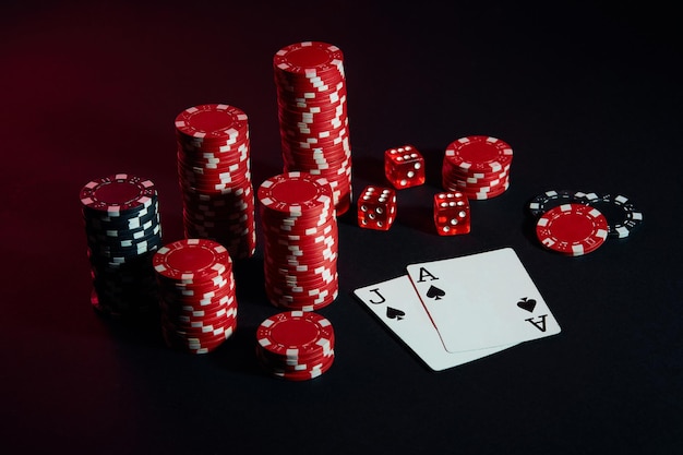 Красные и черные фишки для азартных игр и игральных карт на черном фоне. Натюрморт. Понятие об азартных играх. Покер онлайн. Скопируйте пространство. Идеально подходит для рекламы. Крупный план.