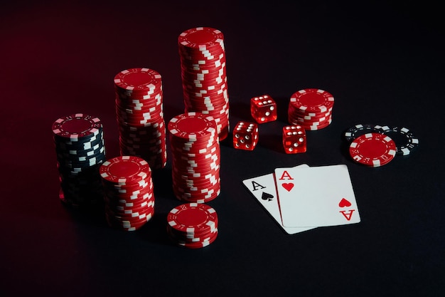 Red and black chips for gambling and playing cards on black background. Still life. The concept of gambling. Poker Online. Copy space. Ideal for advertisement. Close-up.