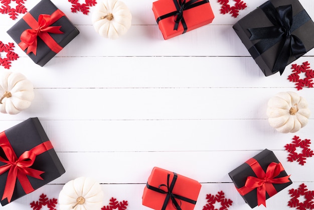 Red and black Christmas boxes, on white wooden background. Black Friday.