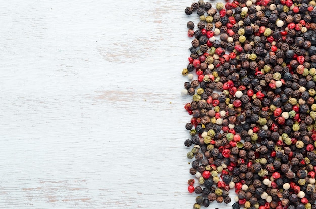 Red and black pepper on a wooden background Spices Top view Free space for your text