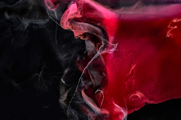 Photo red black pigment swirling ink abstract background, liquid smoke paint underwater