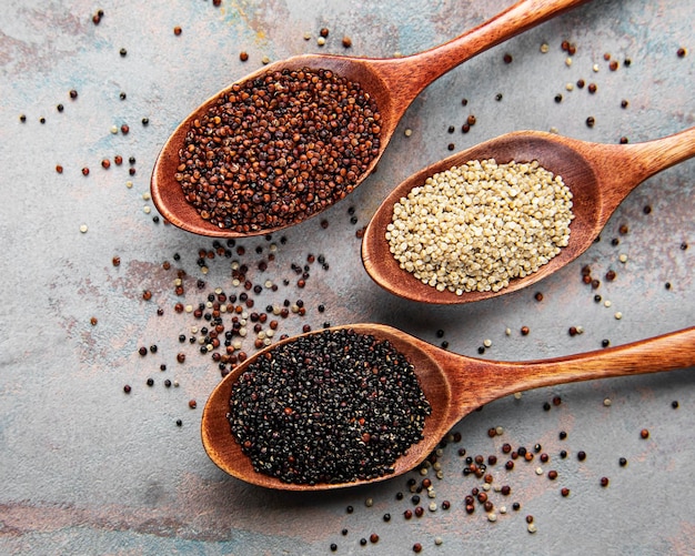 Red black and white quinoa seeds on a concrete background