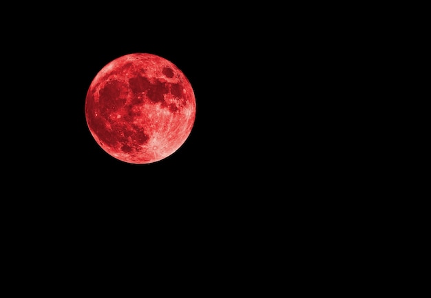 Red bloody moon on black sky as background, full moon