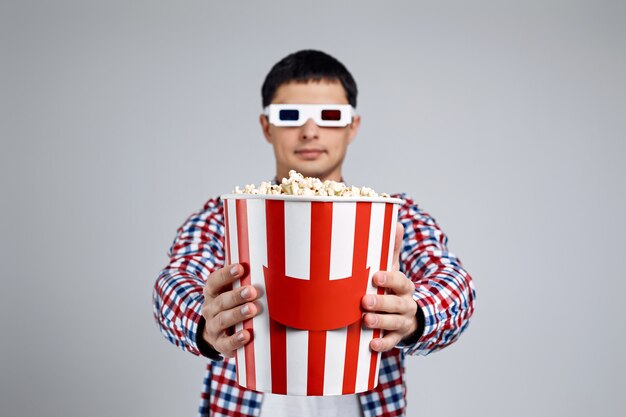 in red-blue 3d glasses showing popcorn bucket on gray